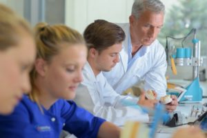 Supervisor checking dentures in lab